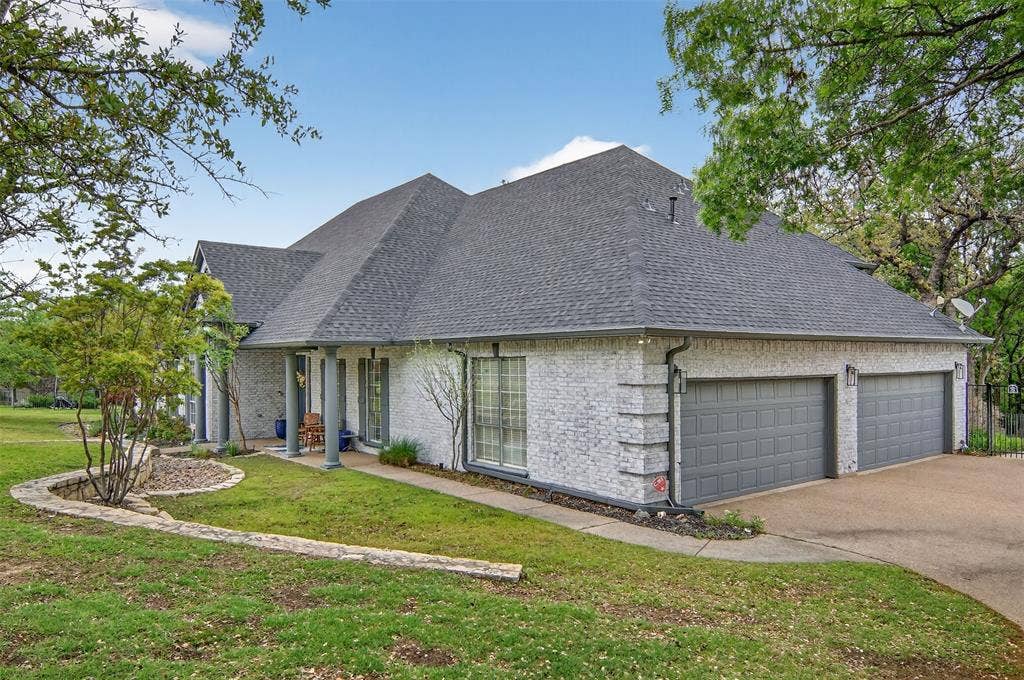 1202 Forest Park Drive, Weatherford, TX 76087 Behind the two large garage doors is an over-sized three-car garage with a workbench and storm shelter.