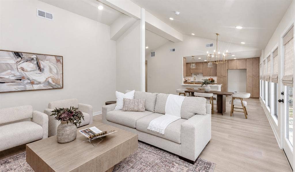 Vaulted ceilings with wall of windows, recessed lighting, wood-finish flooring, add to the contemporary look