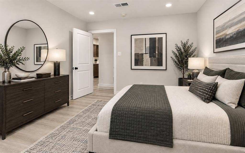 Bedroom 3 has recessed lighting illuminates the neutral wall tones and light wood-finish lpv flooring