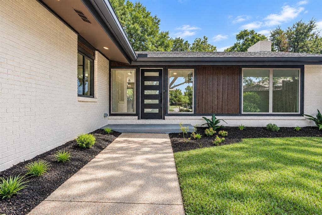 13924 Tanglewood PlaceWhitewashed brick exterior with dark wood paneling, a contemporary entry door, and large new windows enhance the entry