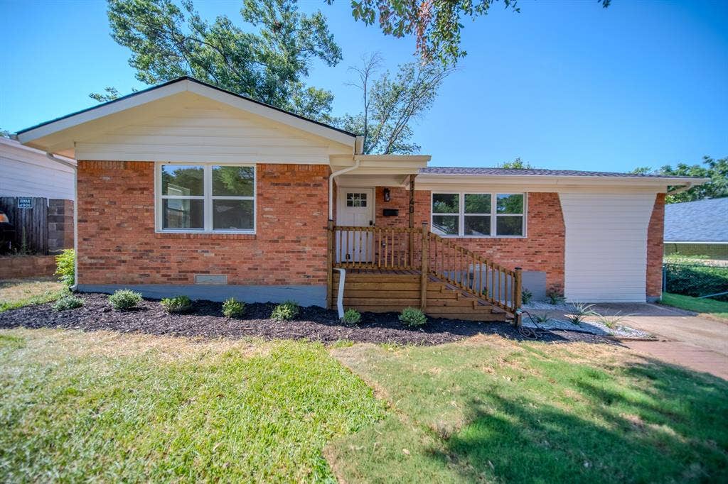 Brick exterior with white siding accents and a contrasting dark roof
