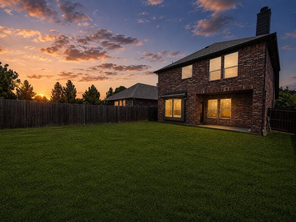 1709 Belton Drive, Prosper, TX 75078 Expansive backyard featuring a manicured lawn, full privacy fencing, and mature perimeter trees