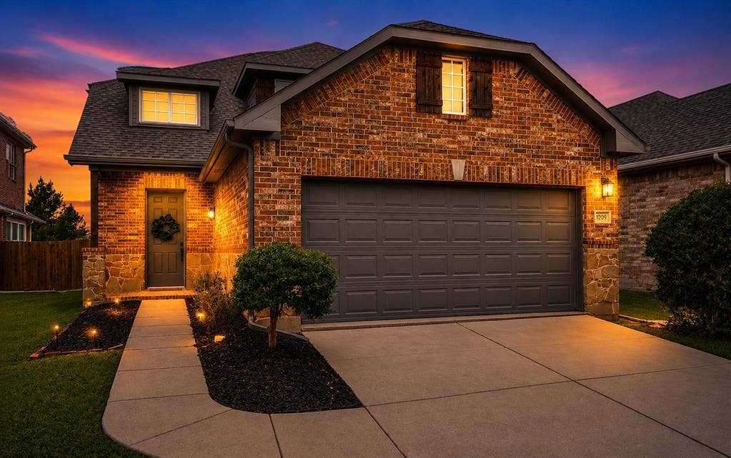 1709 Belton Drive, Prosper, TX 75078 Brick and stone facade featuring a two-car garage, dormer window with shutters, and a concrete driveway