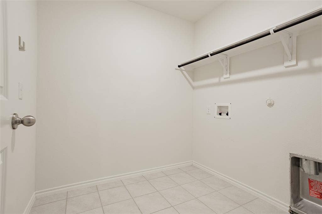 2904 Goodrich Street, Royse City, TX 75189 Utility room featuring tile flooring, white baseboards, a built-in shelf with a hanging rod, and appliance hookups