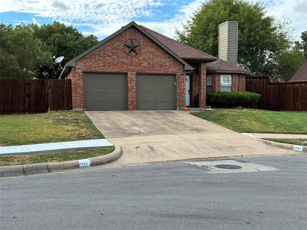 2062 Bronco Lane, Keller, TX 76248 Brick facade residence with a two-car garage, concrete driveway, fenced perimeter, and a pitched roof