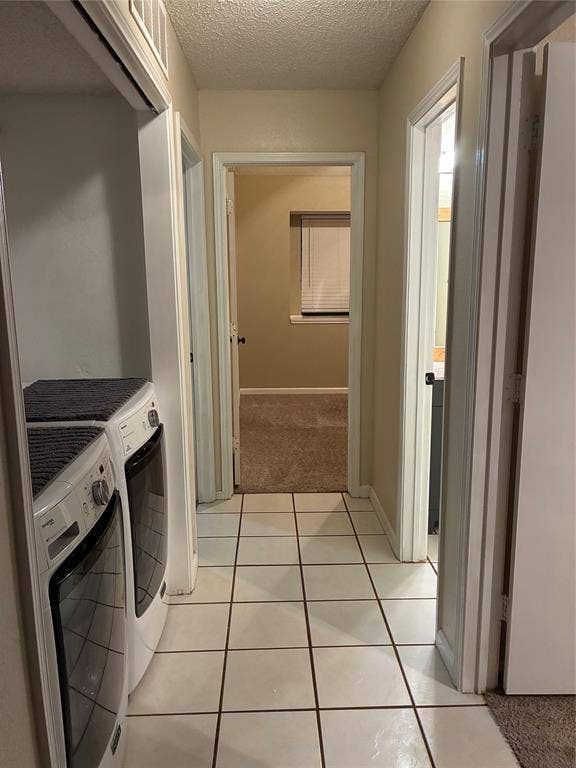 2062 Bronco Lane, Keller, TX 76248 Hallway featuring tile flooring, multiple doorways, and a dedicated laundry area with stacked appliances