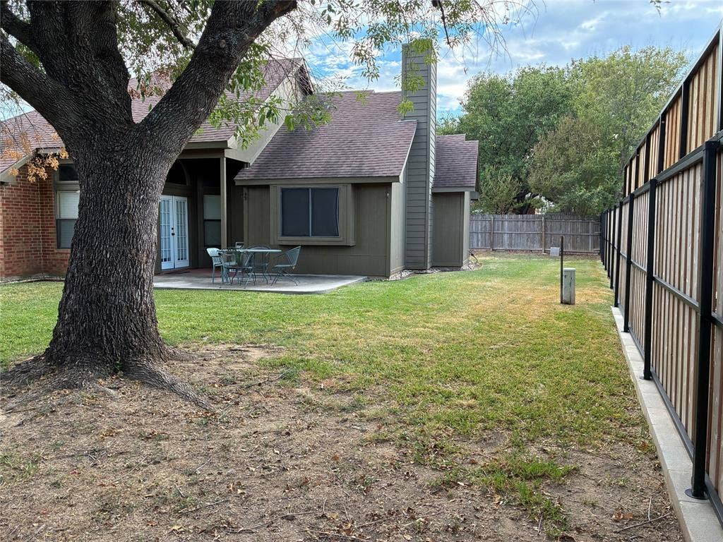 2062 Bronco Lane, Keller, TX 76248 Expansive backyard with a concrete patio, wood-paneled and brick exterior, and a privacy fence