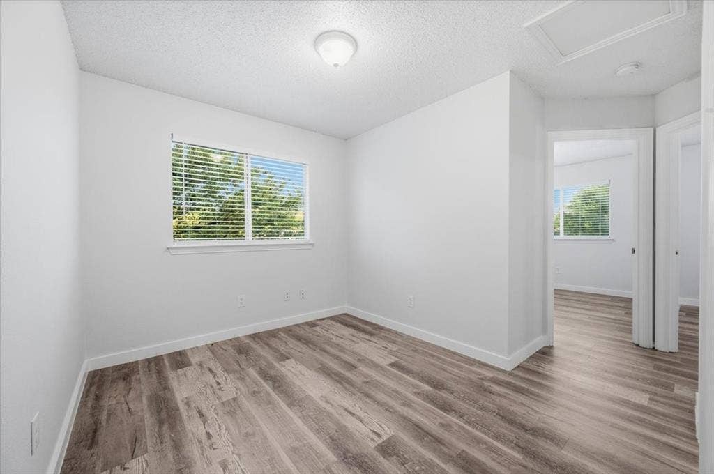 2122 W E Roberts Drive, Grand Prairie, TX 75051 Room featuring wood-finish flooring, a window with blinds, and white walls