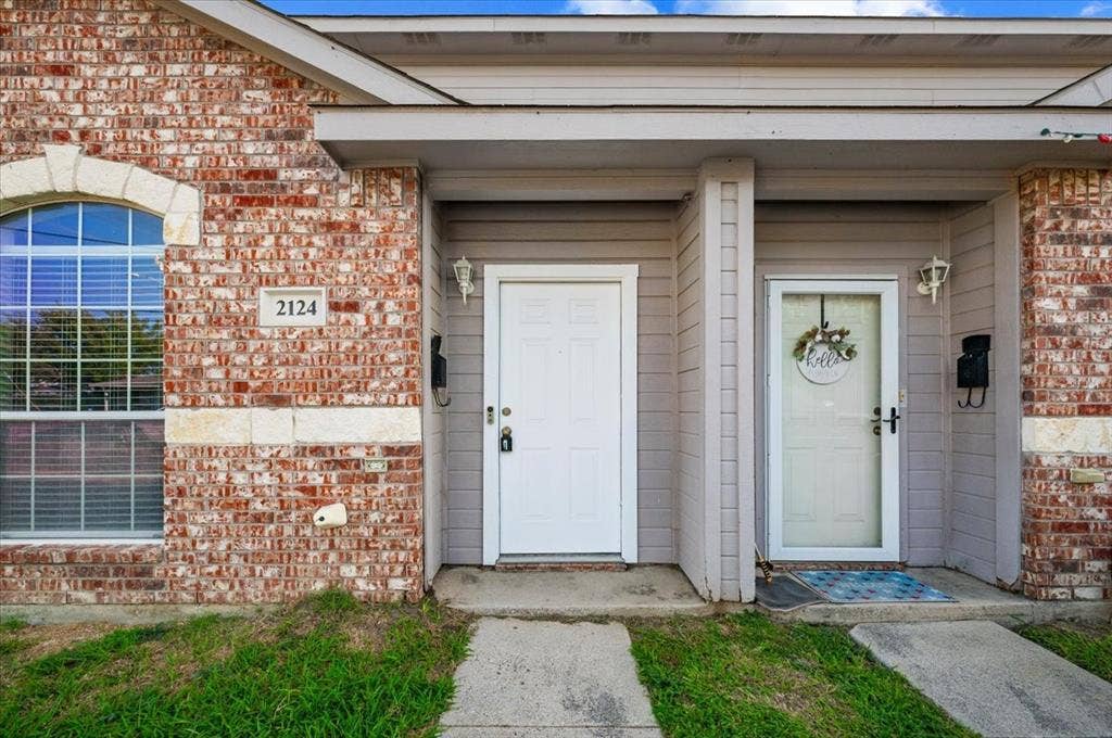 2122 W E Roberts Drive, Grand Prairie, TX 75051 Brick and siding exterior featuring an arched window with stone trim