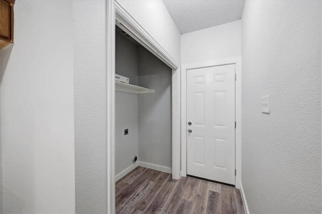 2122 W E Roberts Drive, Grand Prairie, TX 75051 Dedicated laundry closet with built-in shelving, wood-finish flooring, and light-toned walls