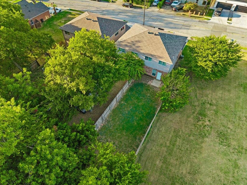 2122 W E Roberts Drive, Grand Prairie, TX 75051 Two-story residence with a gray exterior, a shingled roof, and a private fenced yard