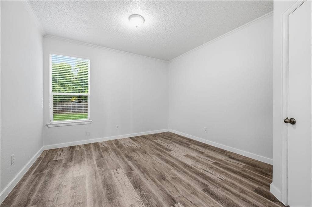 2122 W E Roberts Drive, Grand Prairie, TX 75051 Room featuring wood-finish flooring, crisp white walls, and a window with blinds