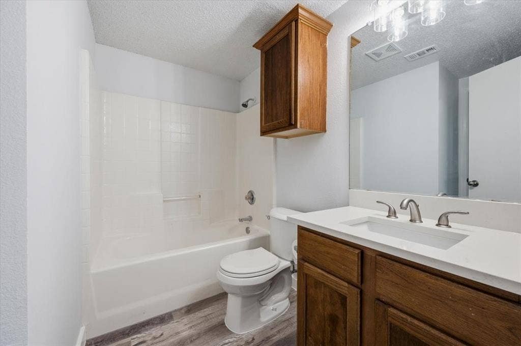 2122 W E Roberts Drive, Grand Prairie, TX 75051 Bathroom featuring a single vanity with a white countertop, undermount sink, and wood-finish cabinetry