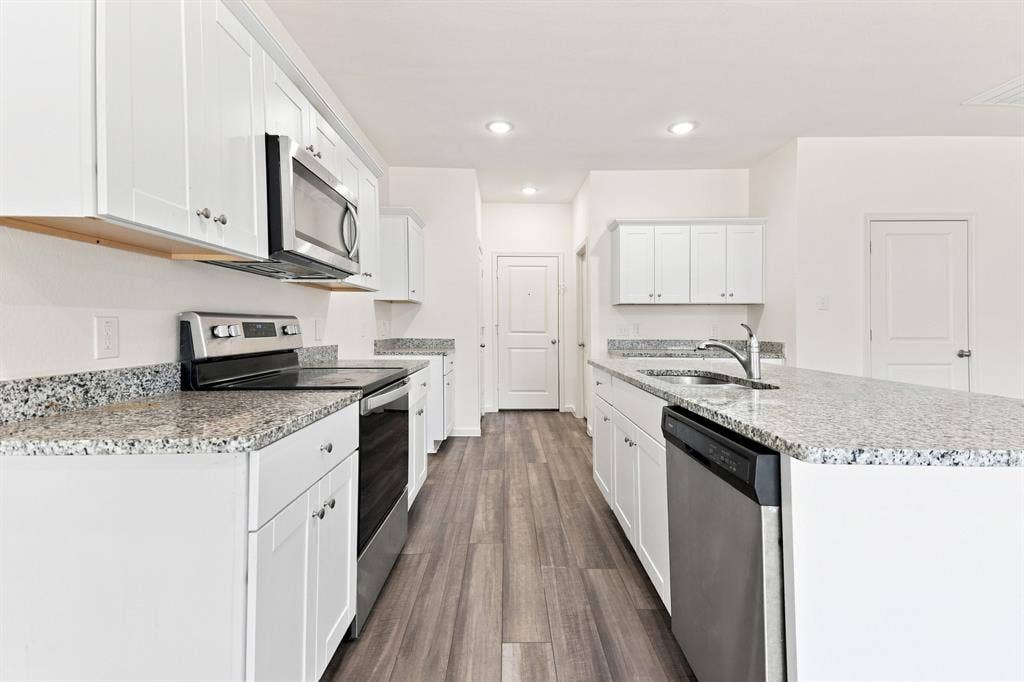 6520 Calico Lane, Forney, TX 75126 Contemporary kitchen featuring white cabinetry and granite countertops