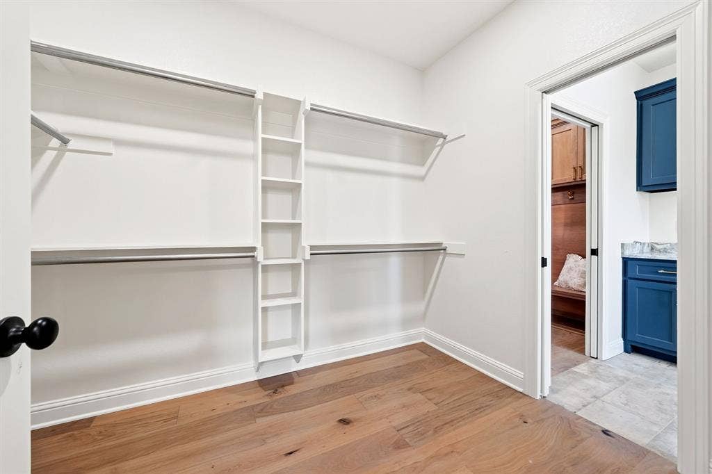 Spacious primary walk-in closet seamlessly flows from the primary en-suite to the laundry room.