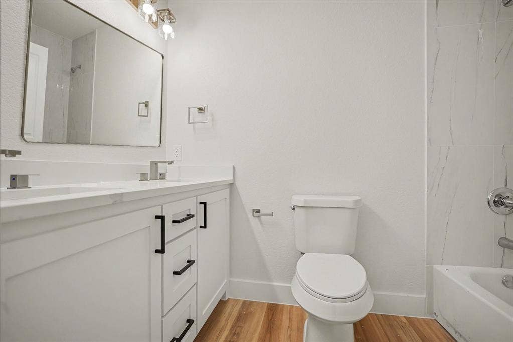 Dual vanity with white cabinetry and black hardware, complete with undermount sinks and contemporary chrome faucets