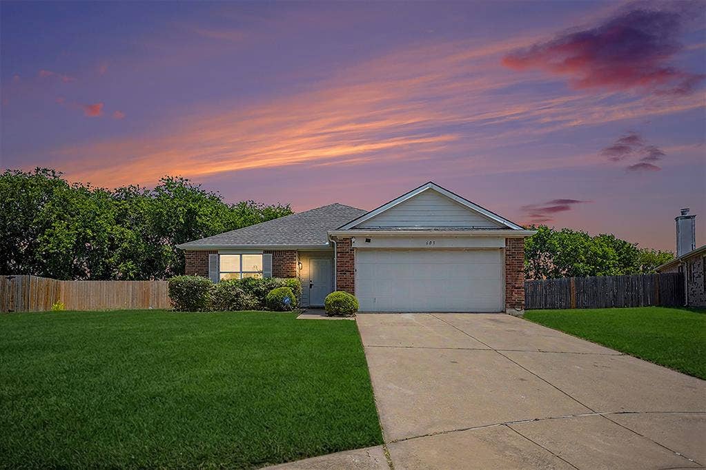 Charming single-story brick home with a two-car garage and manicured lawn