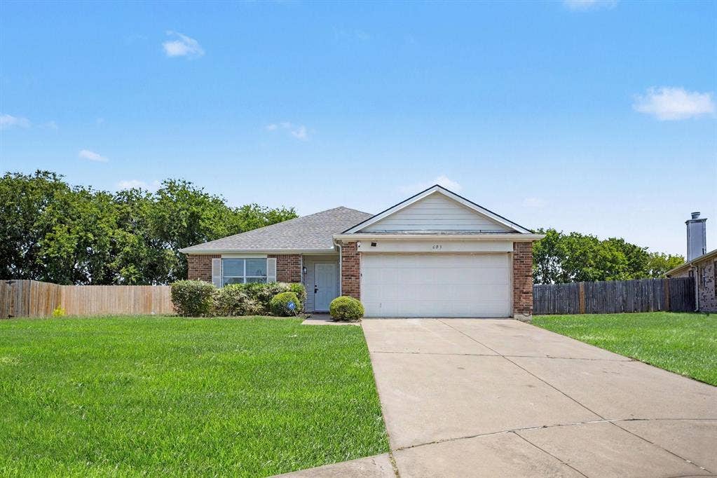 Charming one-story brick residence featuring a welcoming front elevation with peaked roofline, blue entry door, and two-car garage