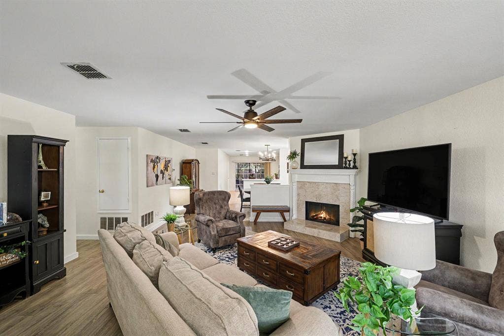 3123 Melrose Drive, McKinney, TX 75070 Spacious living room with wood burning fireplace, looks into dining room and kitchen