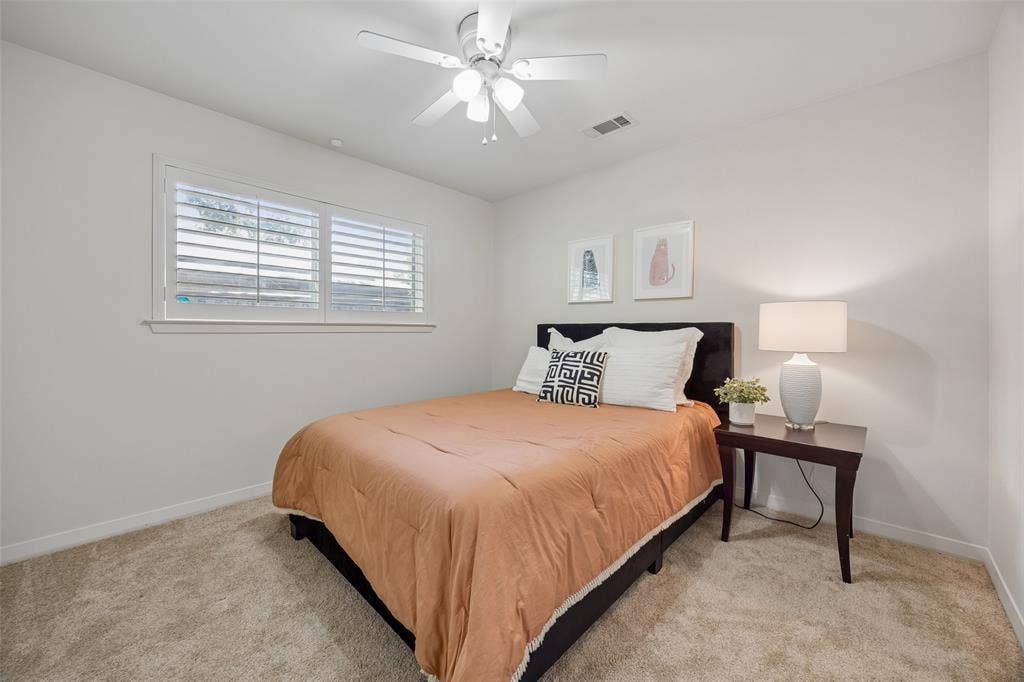 4110 Shady Hill Drive, Dallas, TX 75229 A spacious downstairs bedroom with abundant natural light and private access to a Jack-and-Jill bath.