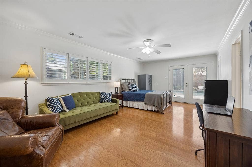 4110 Shady Hill Drive, Dallas, TX 75229 A spacious downstairs bedroom offers wood floors, french doors to the backyard and plenty of room for additional seating or a workspace. Private bathroom attached.