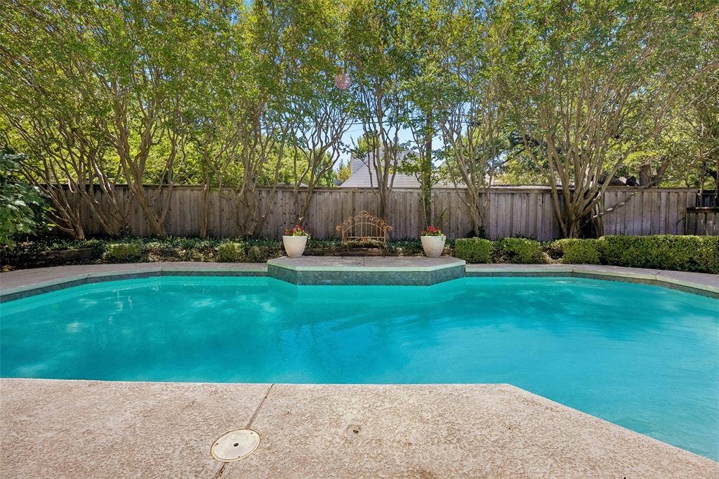 4110 Shady Hill Drive, Dallas, TX 75229 The expansive backyard pool is framed by mature trees and lush landscaping, creating a serene setting for outdoor living and entertaining. Additonal green space not photographed.