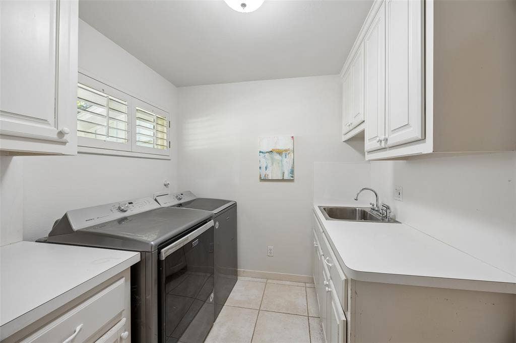 4110 Shady Hill Drive, Dallas, TX 75229 A spacious laundry room offers abundant cabinetry, generous counter space, a utility sink, and natural light.