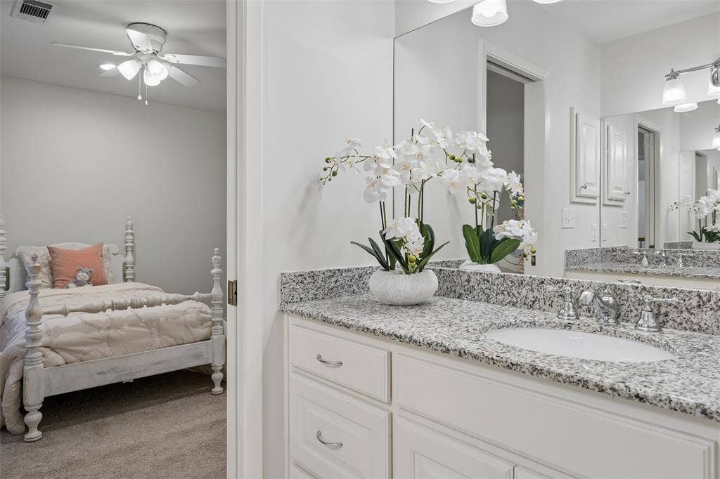 4110 Shady Hill Drive, Dallas, TX 75229 An upstairs Jack-and-Jill bath features two granite-topped vanity and convenient access to the adjoining bedrooms.