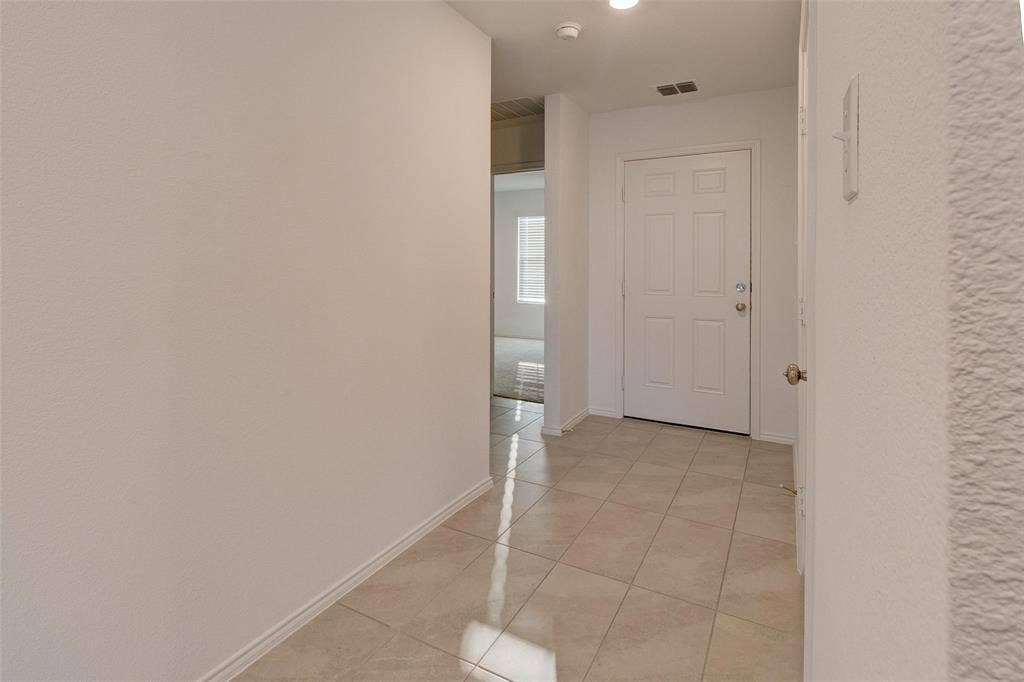 6005 Determine Lane, Forney, TX 75126 Entryway featuring light-toned square tile flooring, a white paneled door, and neutral wall finishes