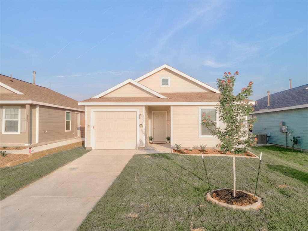 6005 Determine Lane, Forney, TX 75126 Single-story residence featuring light-colored siding, an attached garage, and a concrete driveway
