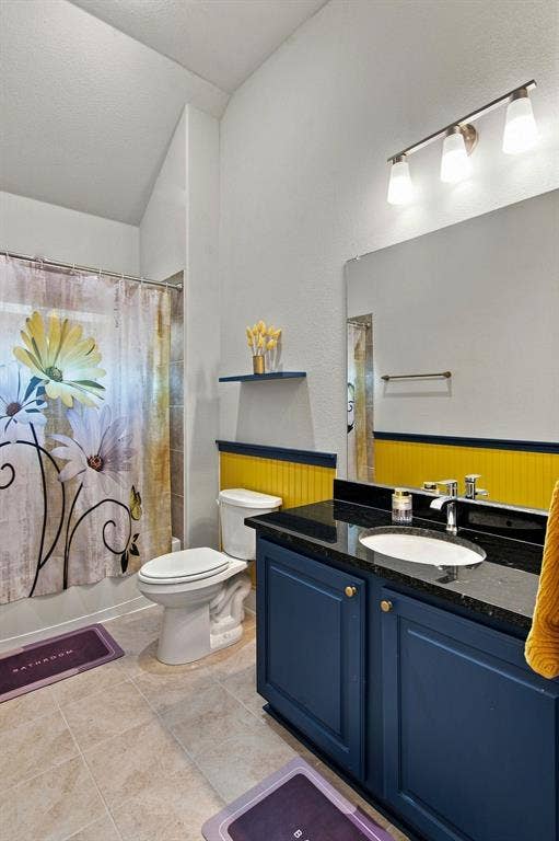 944 Tara Court, Haslet, TX 76052 Bathroom featuring a dark blue vanity with a polished countertop, a built-in sink, and a wall-mounted mirror