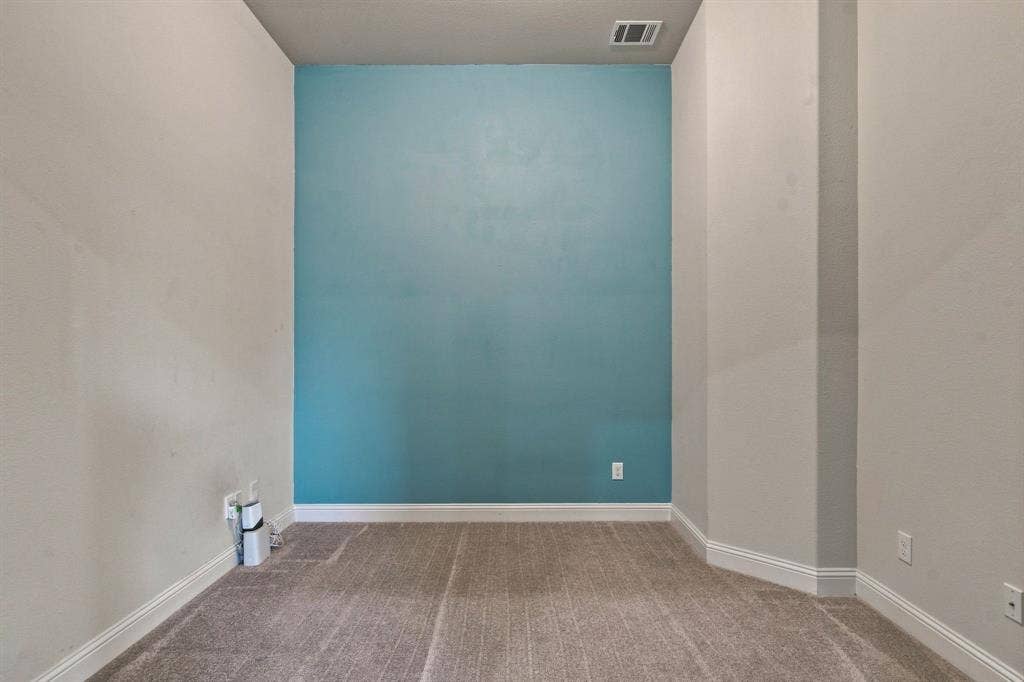 944 Tara Court, Haslet, TX 76052 Room featuring a vibrant accent wall, neutral carpeting, and white baseboards
