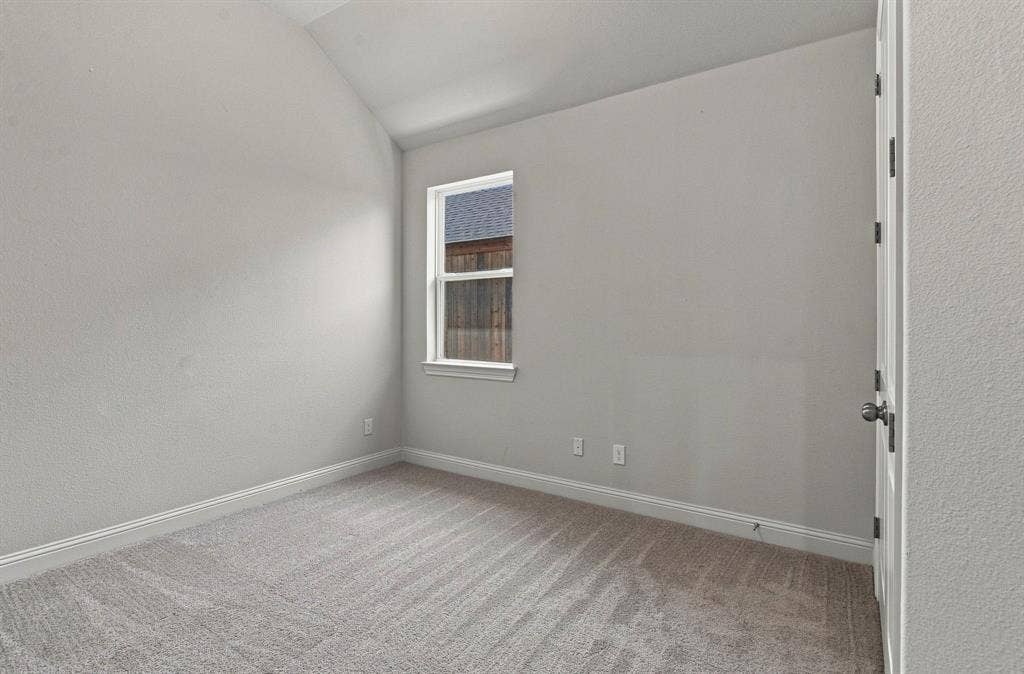 944 Tara Court, Haslet, TX 76052 Neutral gray walls featuring an angled ceiling and textured carpeting
