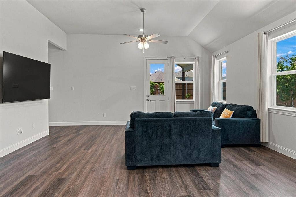 944 Tara Court, Haslet, TX 76052 Spacious living area featuring wood-finish flooring, vaulted ceilings, and a ceiling fan with integrated lighting