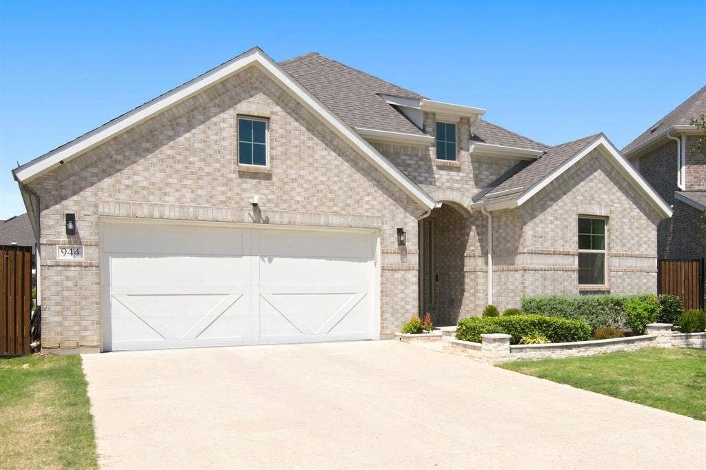 944 Tara Court, Haslet, TX 76052 Contemporary brick exterior with a two-car garage, dormer windows, landscaped front yard, and a paved driveway