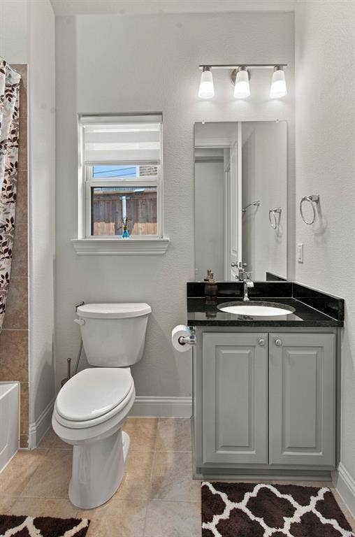 944 Tara Court, Haslet, TX 76052 Bathroom featuring a gray vanity with a dark countertop, an undermount sink, and a framed mirror