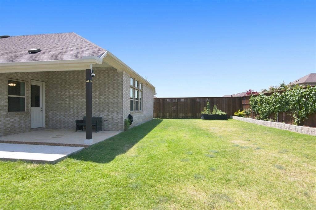 944 Tara Court, Haslet, TX 76052 Expansive backyard featuring a concrete patio, a privacy fence, and a raised garden bed