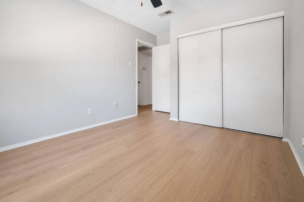 Room featuring light wood-finish flooring, light gray walls, and white baseboards