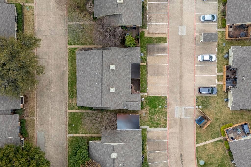 Community layout featuring mature trees, concrete paved streets, and off-street parking areas