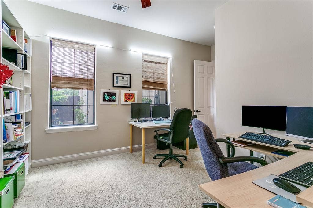 Bedroom currently used as an office, featuring courtyard views and a spacious walk-in closet.