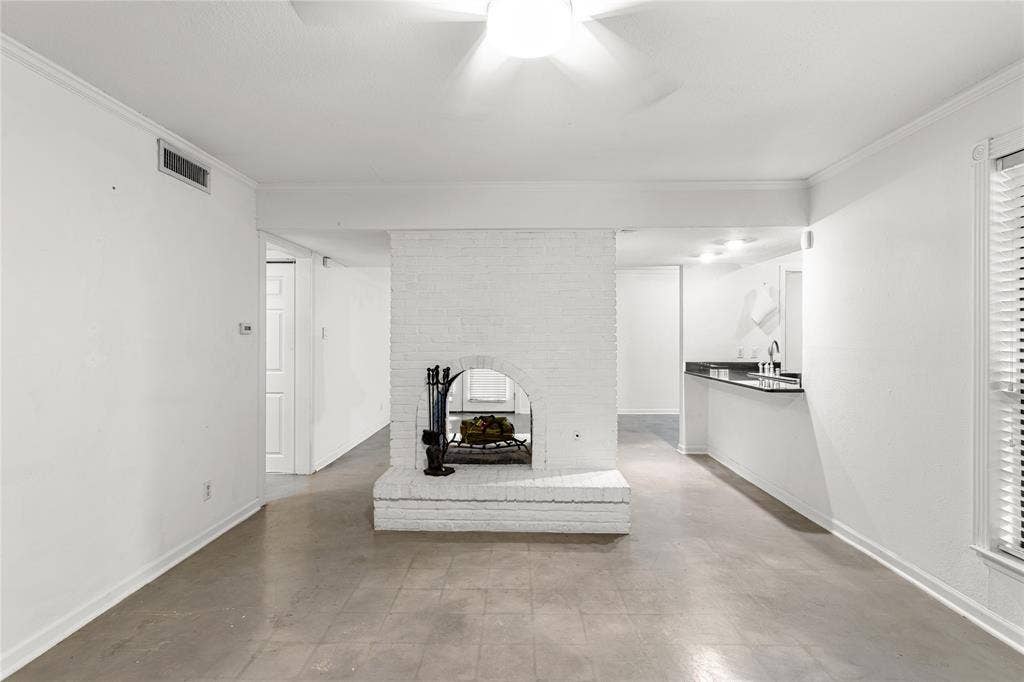 5916 Birchbrook Drive, #129, Dallas, TX 75206 Living area featuring a painted brick fireplace, a ceiling fan with integrated lighting, and tile flooring