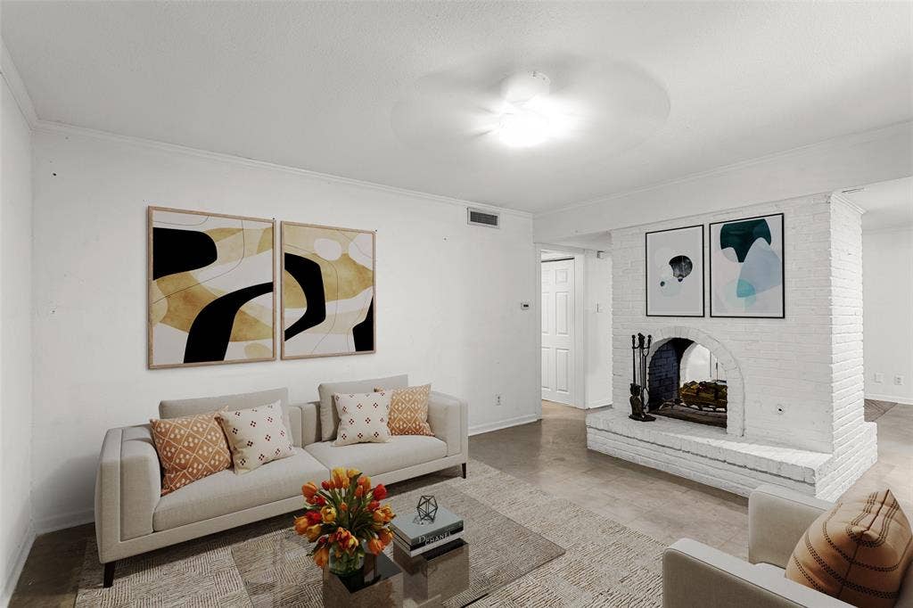 5916 Birchbrook Drive, #129, Dallas, TX 75206 Virtually Staged living area featuring a prominent white painted brick fireplace with an arched firebox