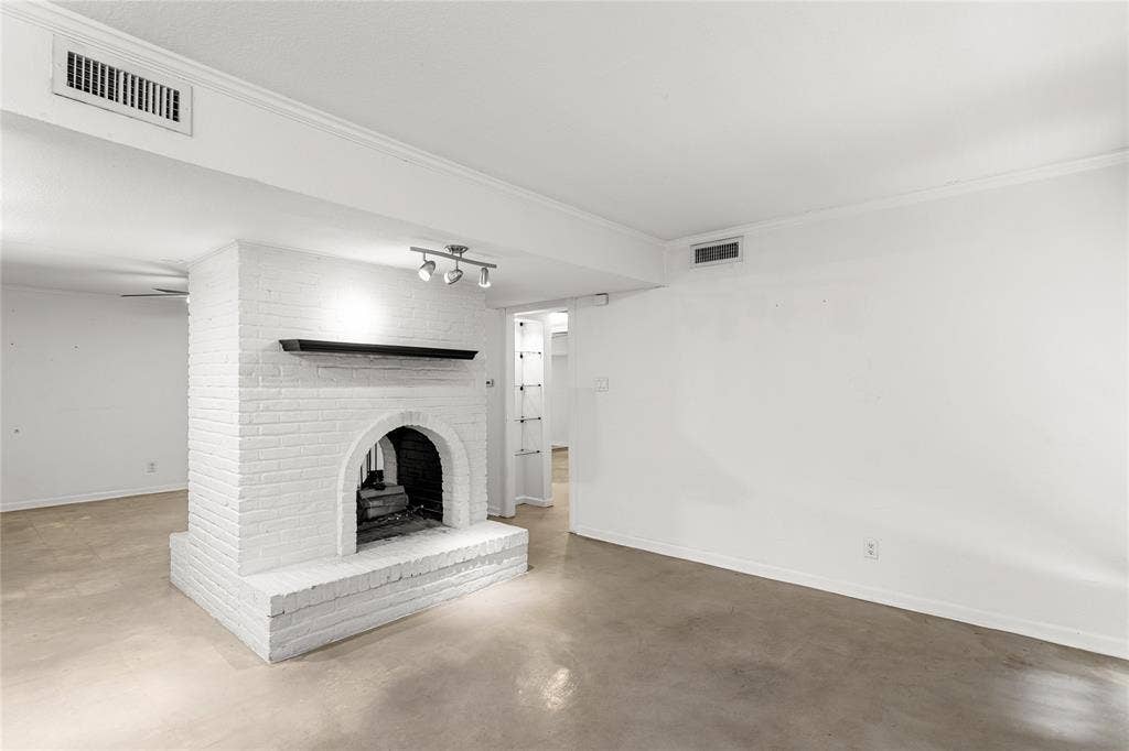 5916 Birchbrook Drive, #129, Dallas, TX 75206 Central brick fireplace with an arched firebox, featuring a dark mantel and track lighting