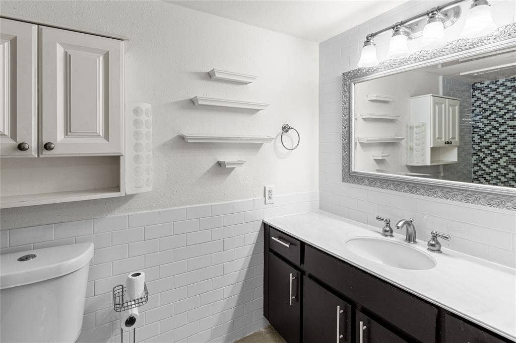5916 Birchbrook Drive, #129, Dallas, TX 75206 Bathroom featuring a vanity with dark wood-finish cabinetry, white countertop, and an undermount sink with brushed nickel fixtures