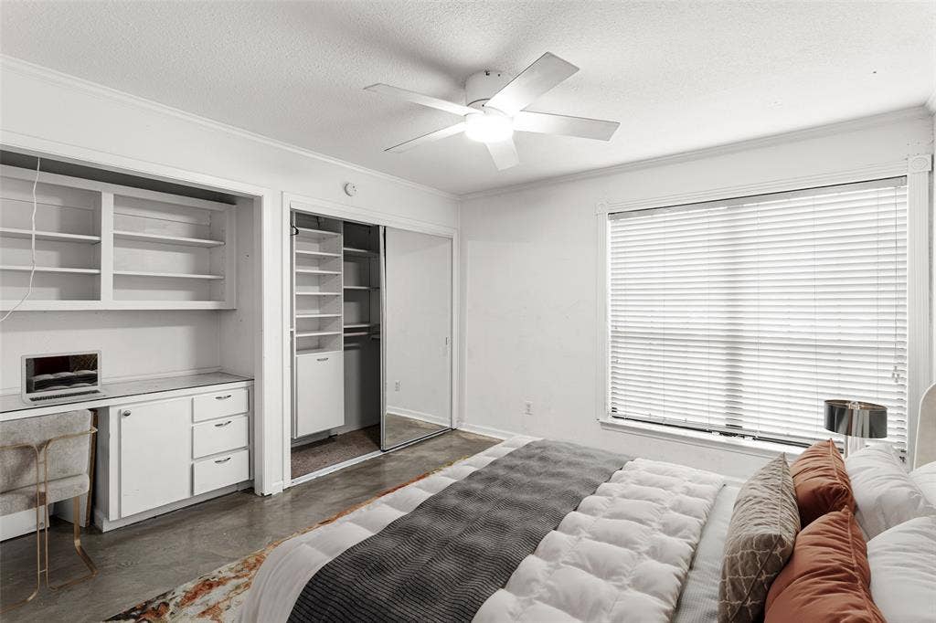 5916 Birchbrook Drive, #129, Dallas, TX 75206 Virtually Staged w/ Built-in desk with overhead shelving, integrated closet organization system with mirrored sliding doors, and a ceiling fan with integrated lighting