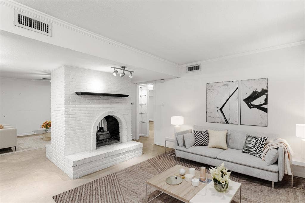 5916 Birchbrook Drive, #129, Dallas, TX 75206 Virtually Staged White brick fireplace with a dark wood mantelpiece