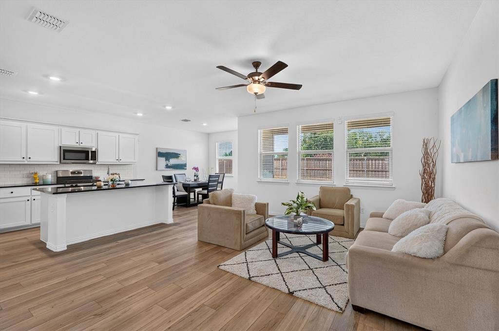 Open-concept living space featuring wood-finish flooring, recessed lighting, and a ceiling fan