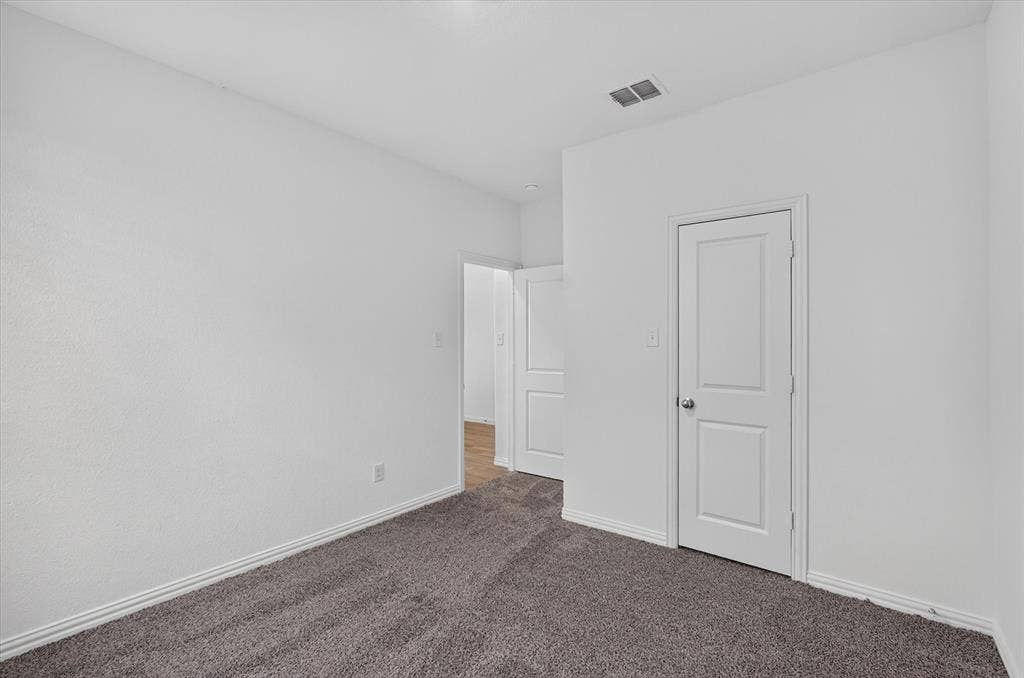 Bedroom with plush gray carpet, white painted walls, and white baseboards