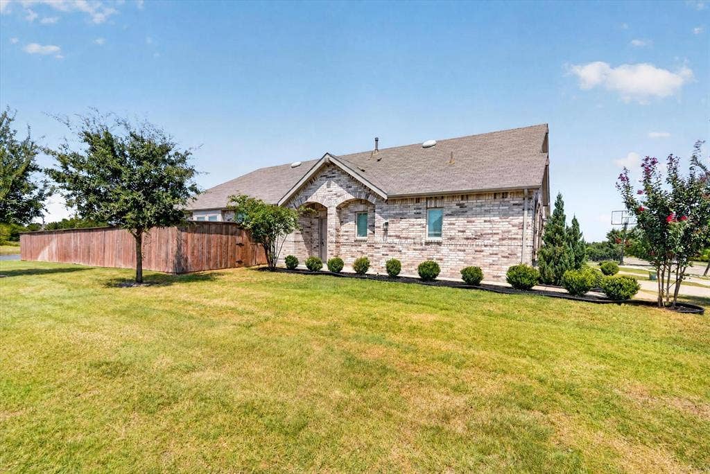 2832 Lolita Way, Forney, TX 75126 Stone exterior with pitched roof and multiple gable peaks, situated on expansive manicured lawn