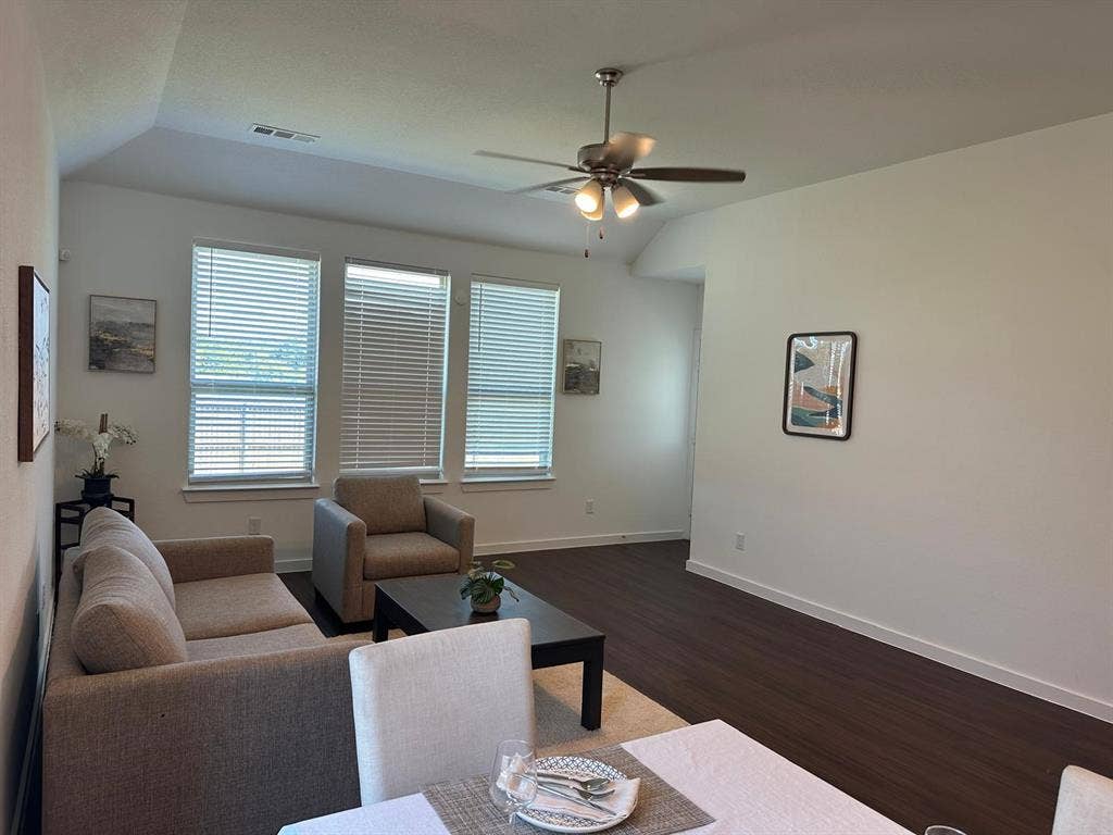 2832 Lolita Way, Forney, TX 75126 Vaulted ceiling with a ceiling fan, three windows with blinds, and wood-finish flooring